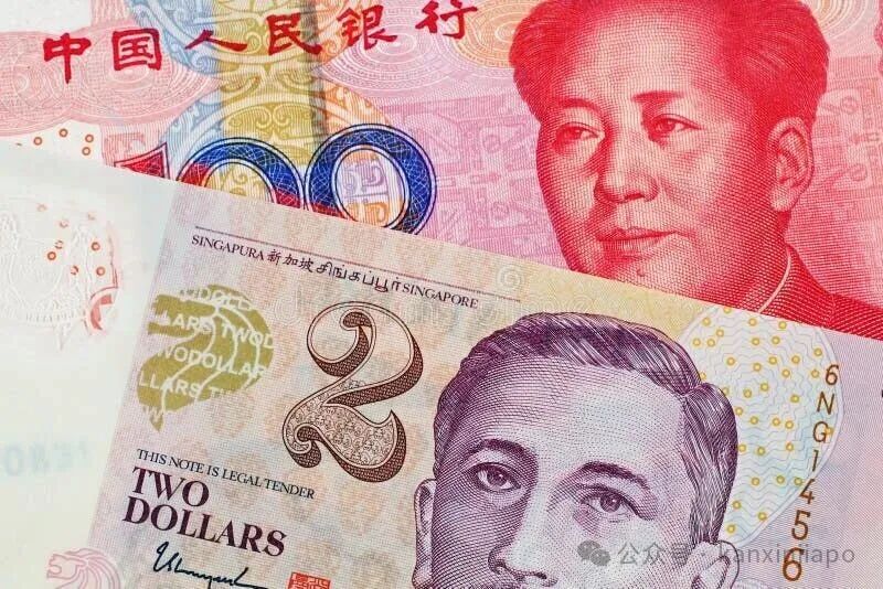 A two Singapore Dollar bank note with a hundred Chinese Yuan banknote. A close up image of a two Singapore Dollar bank note with a hundred Chinese Yuan bank note
